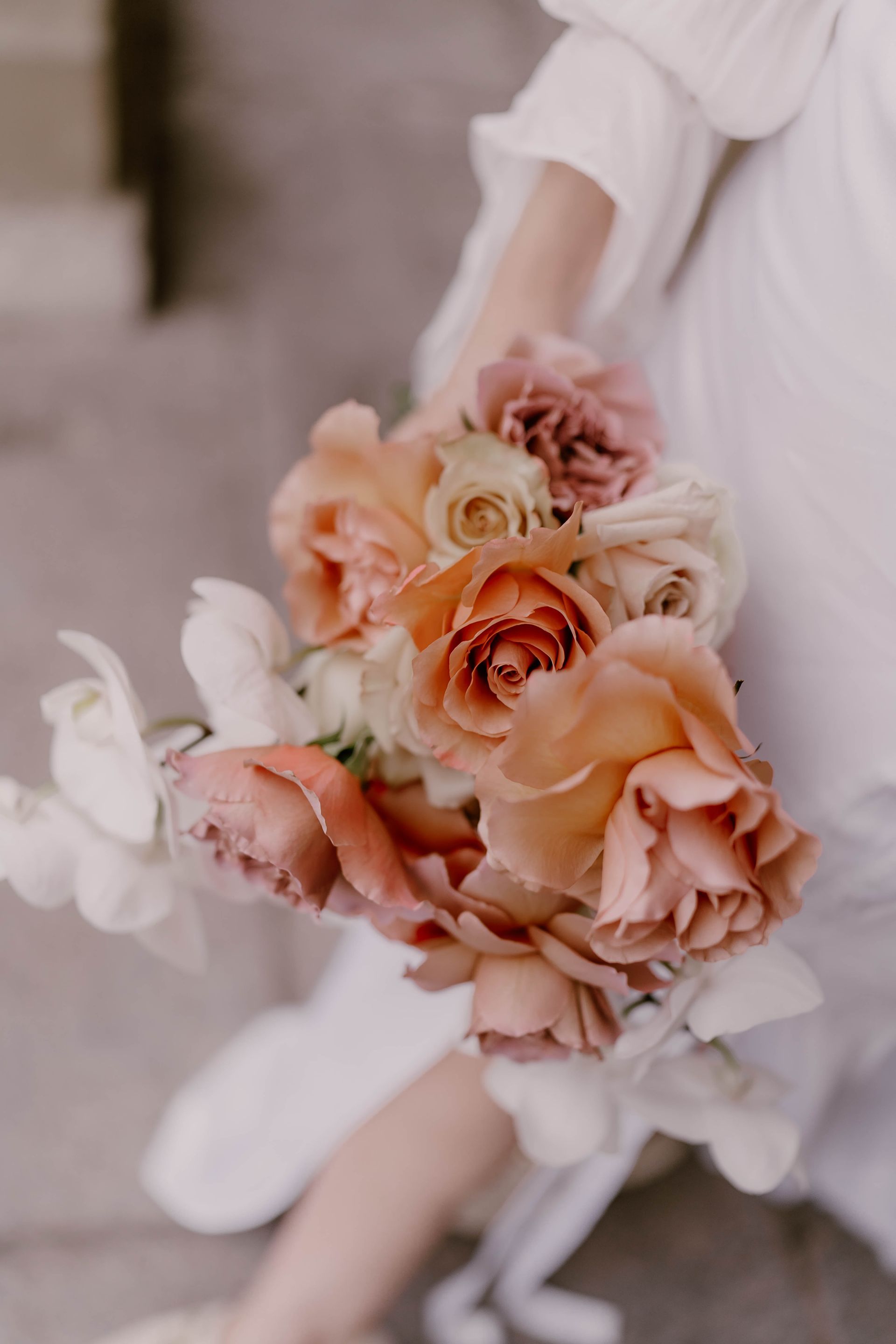 A woman is holding a bouquet of flowers in her hand.