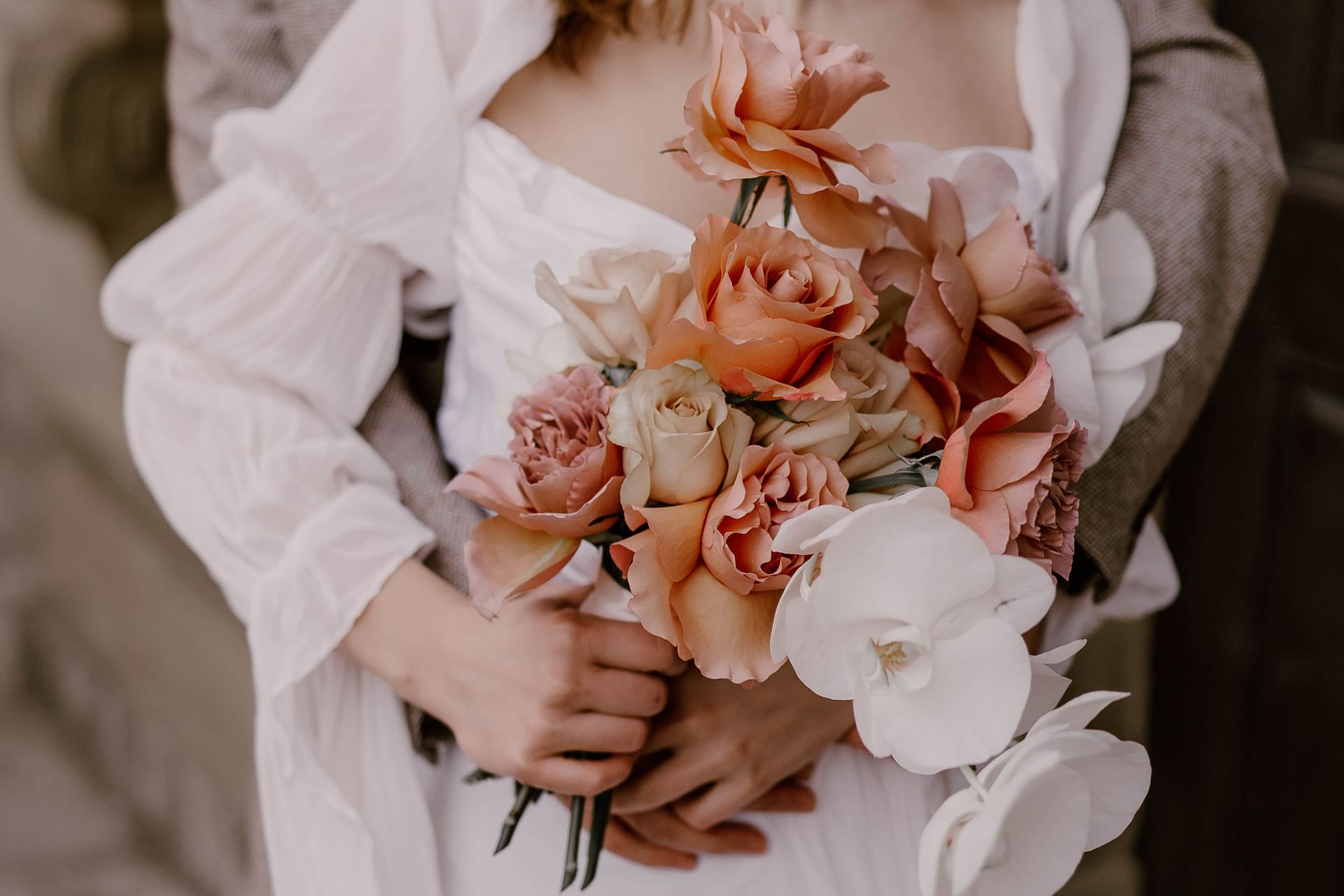 A woman in a white dress is holding a bouquet of flowers.