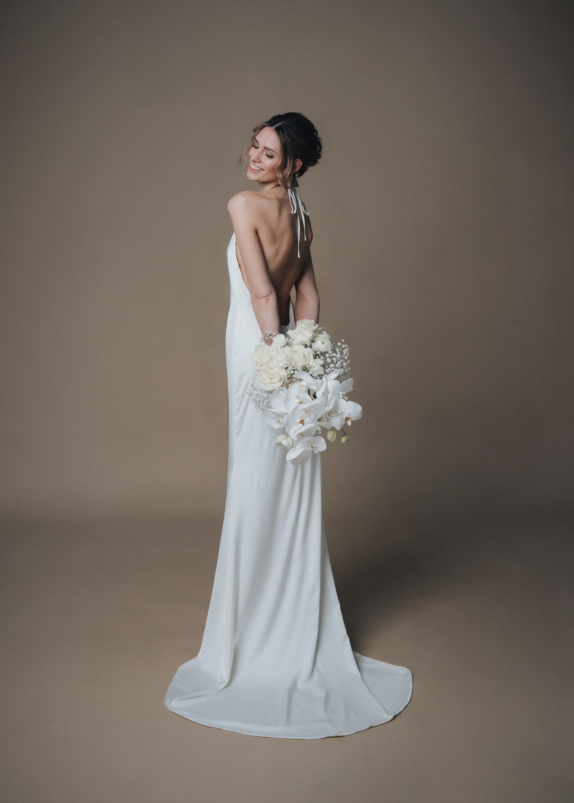 A woman in a white wedding dress is holding a bouquet of flowers.