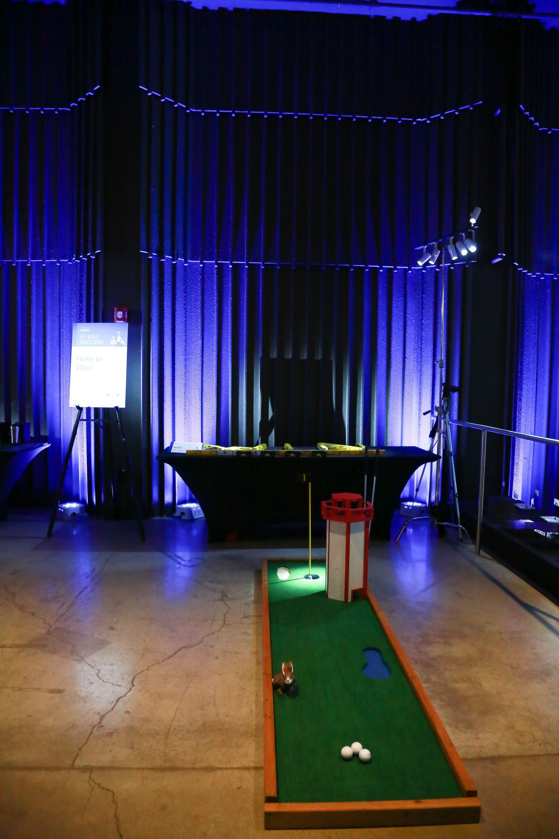 A small golf course in a dark room with blue lights