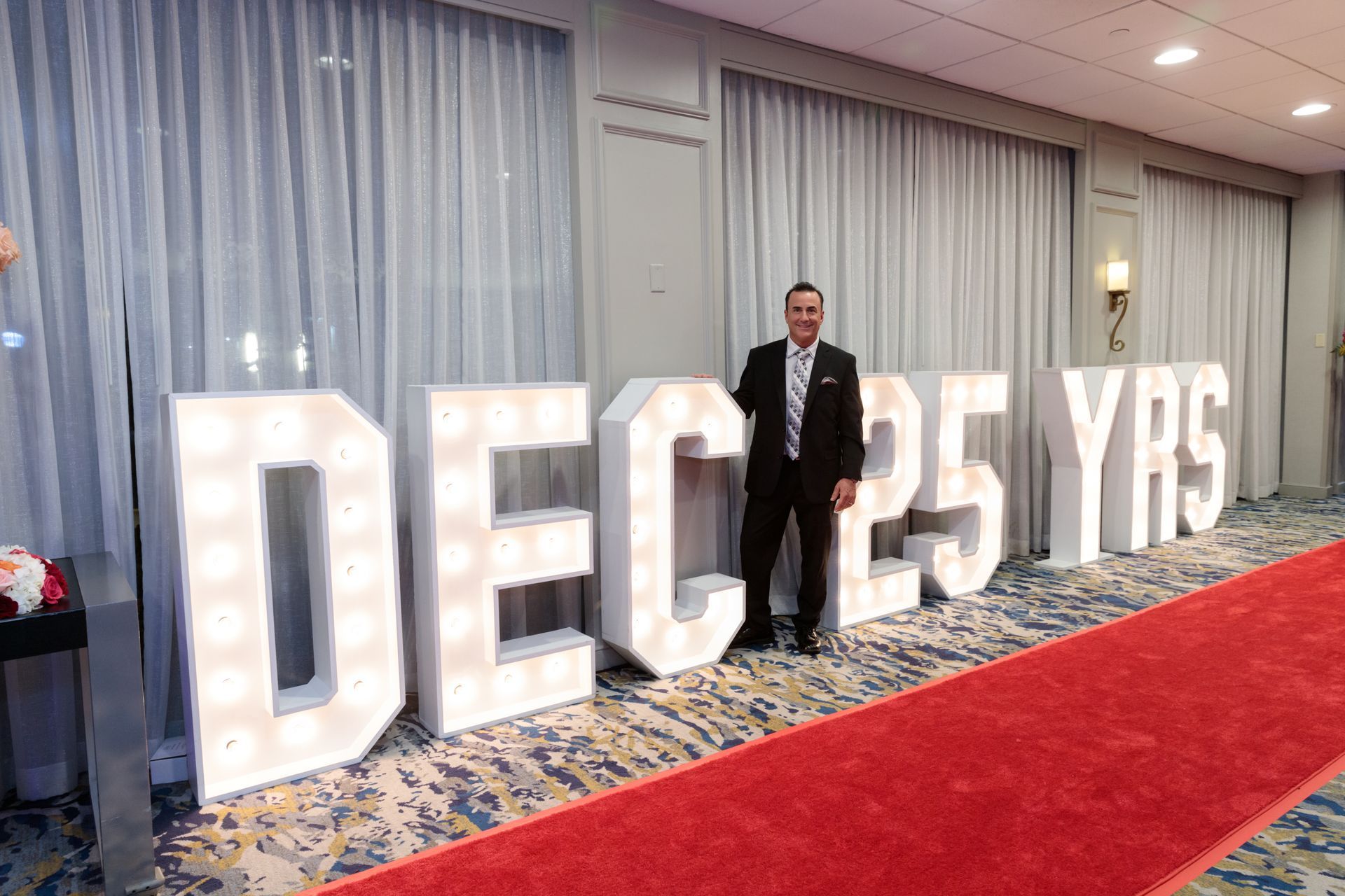 A dj is playing music in a tent next to a pool.