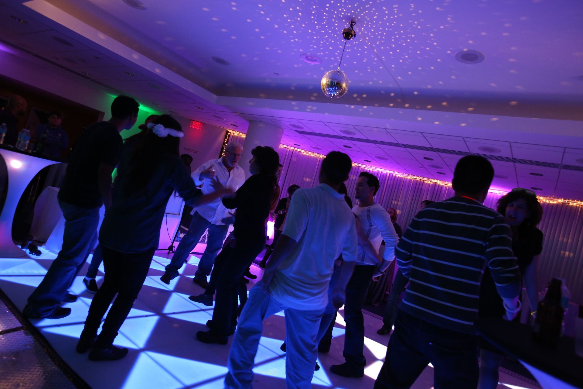 A group of people are dancing on a dance floor