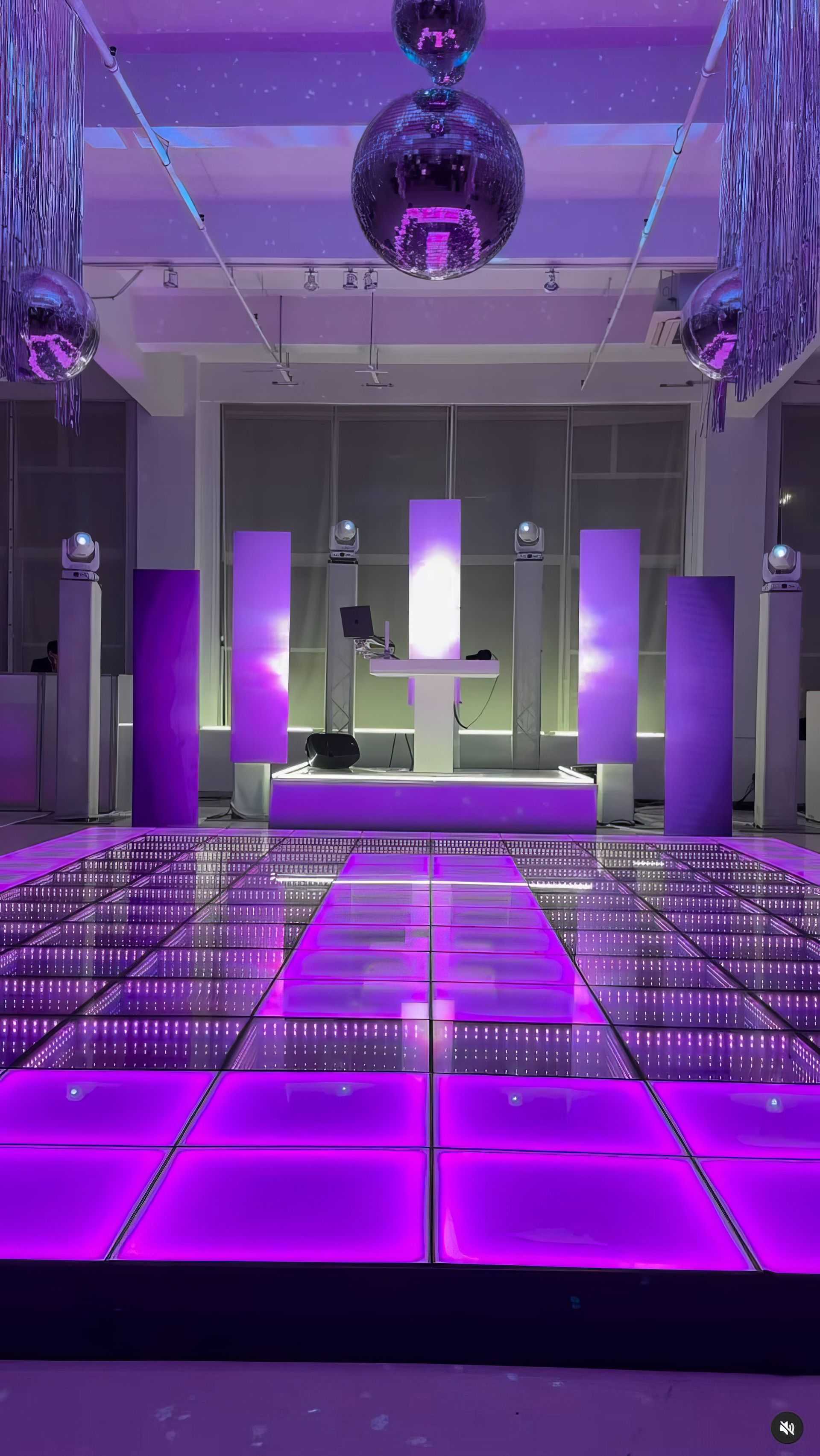 There is a purple dance floor in the middle of the room.