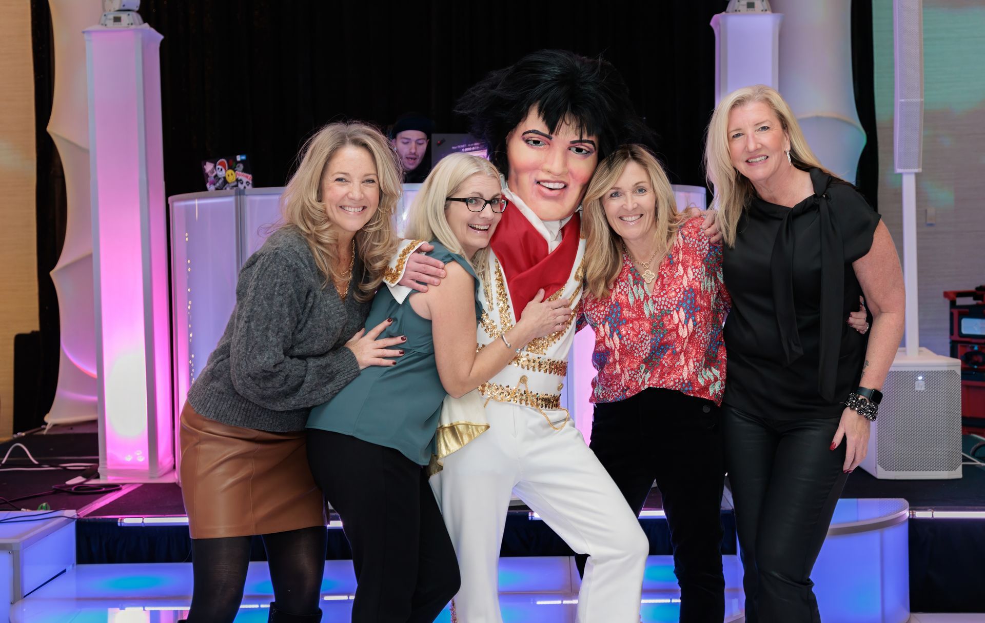 A group of women are posing for a picture with elvis presley.