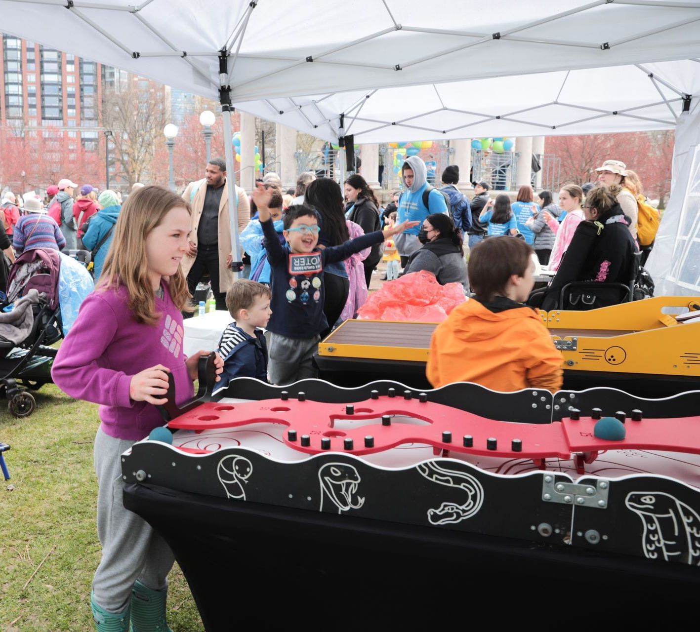 A girl in a purple sweater is standing in front of a table