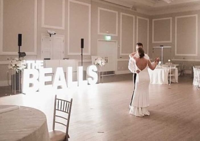 A bride and groom are dancing their first dance at a wedding reception.