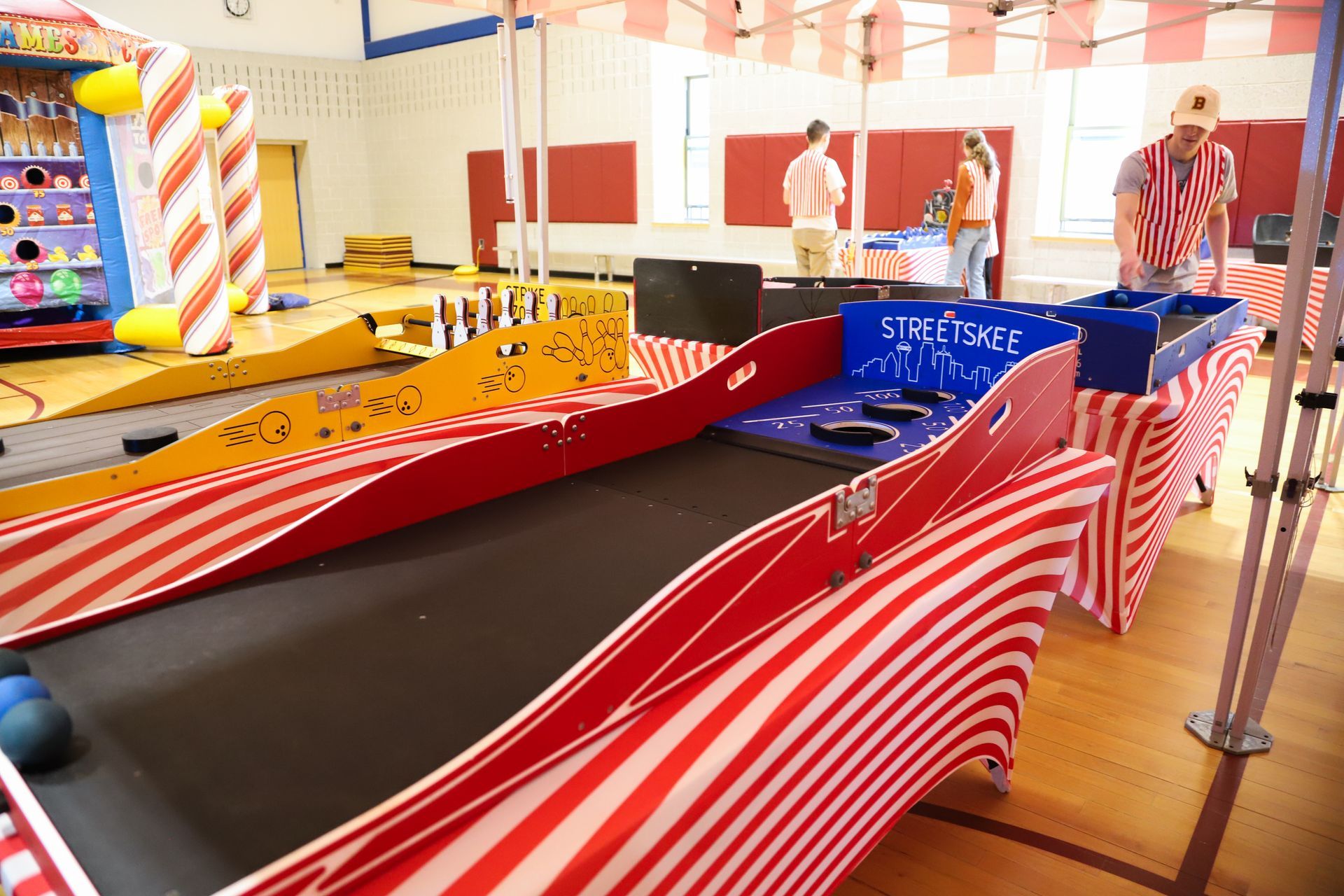 A red and white striped roller coaster in a gym