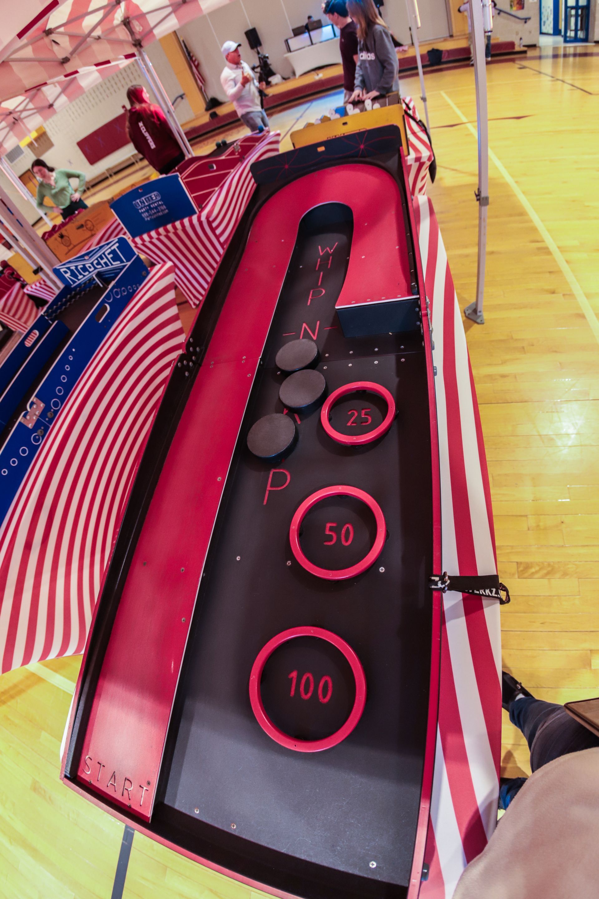 A carnival game is being played on a wooden floor