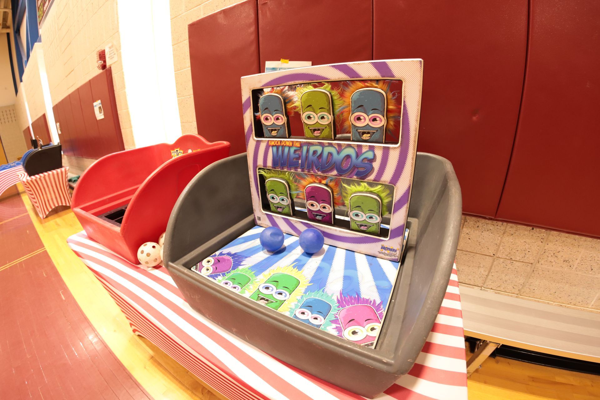 A carnival game is sitting on a table in a gym.