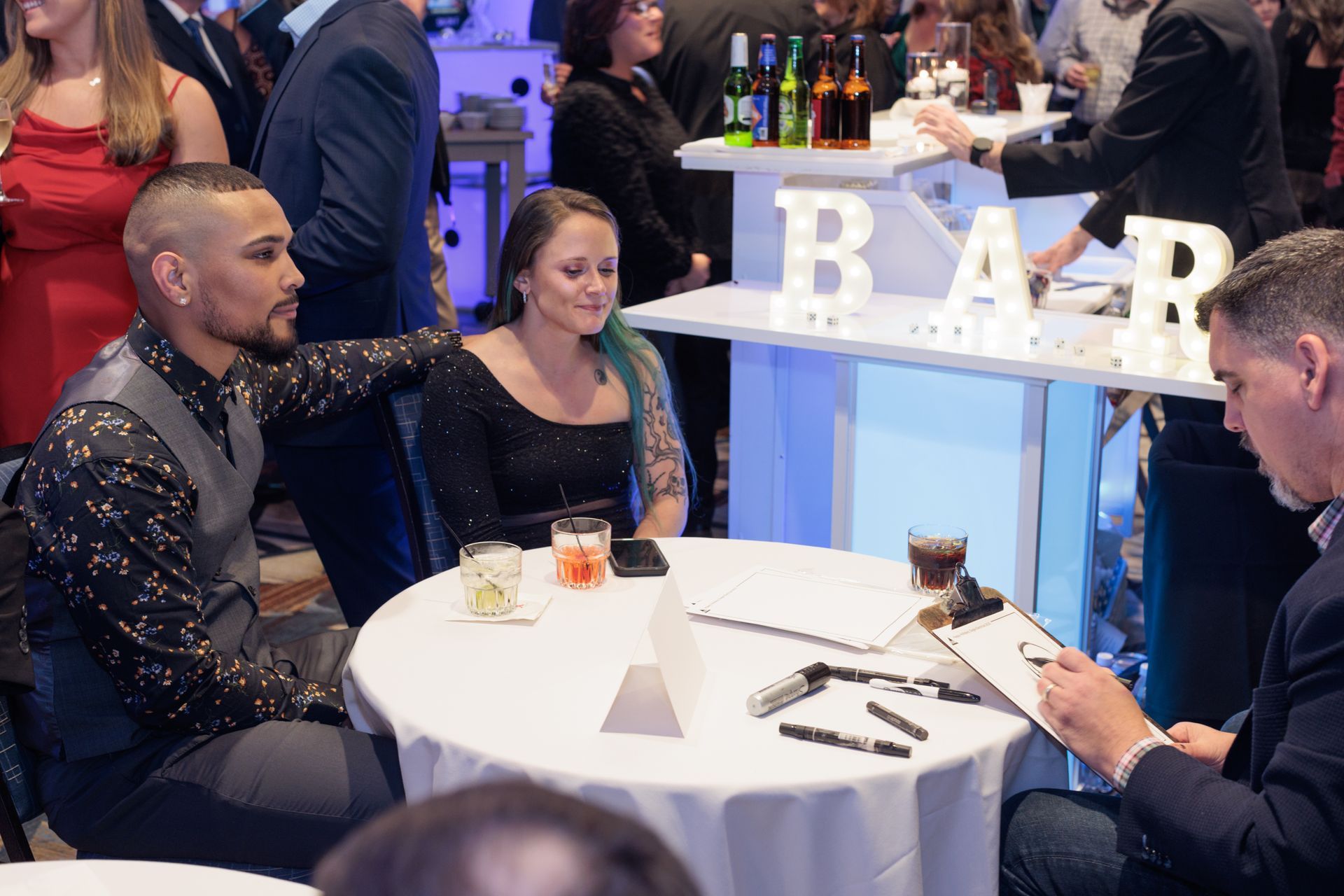 A group of people are sitting around a table at a party.