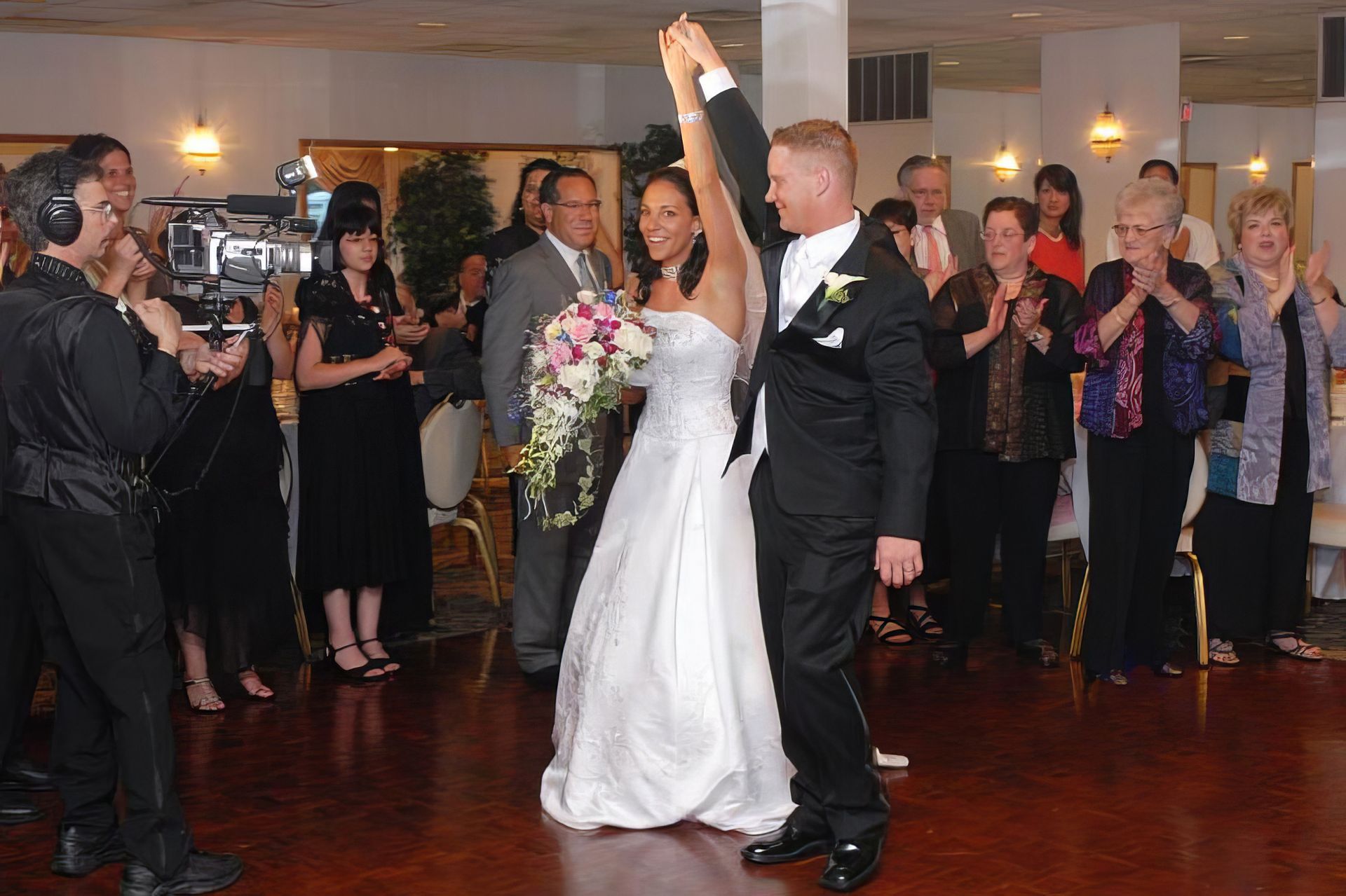A bride and groom are dancing at their wedding reception