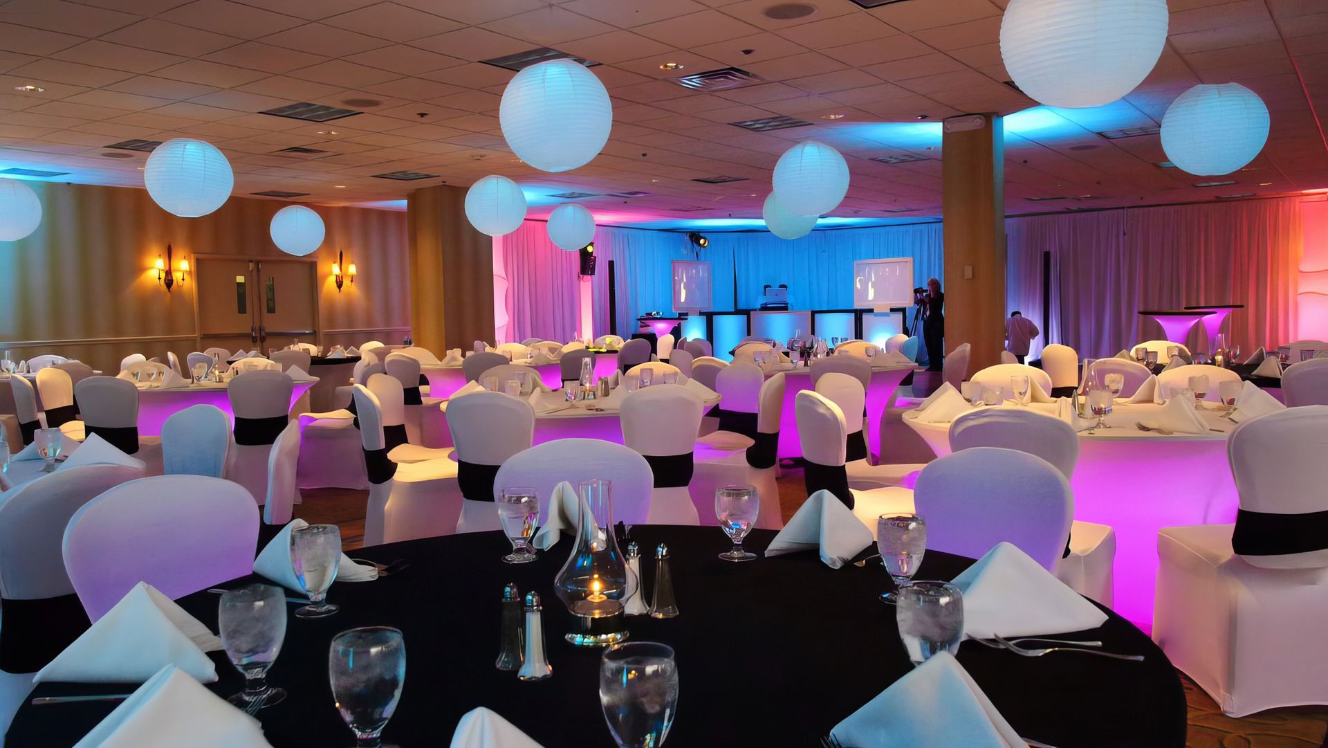 A large room with tables and chairs set up for a party