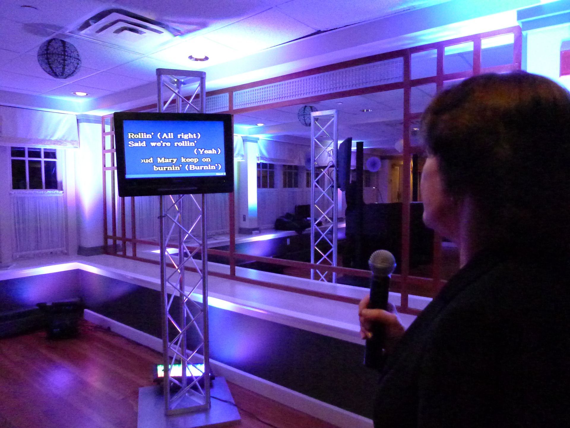 A woman is holding a microphone in front of a screen that says game on it