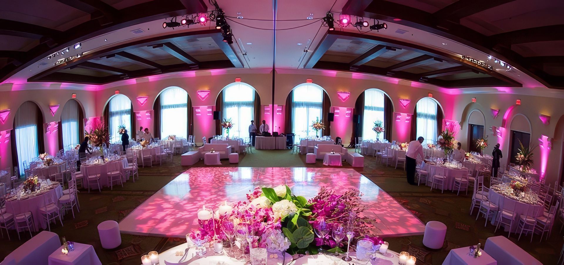 A bride and groom are dancing in front of a crowd of people at their wedding reception.