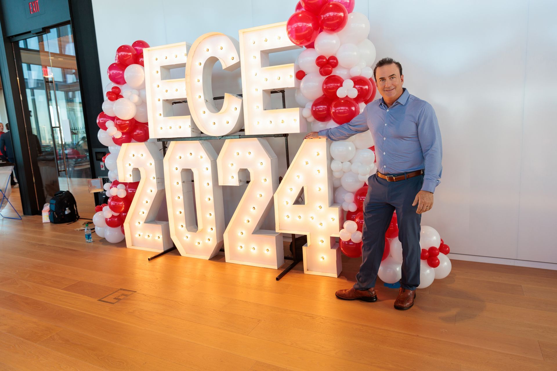 A bride and groom are dancing in front of a crowd of people at their wedding reception.