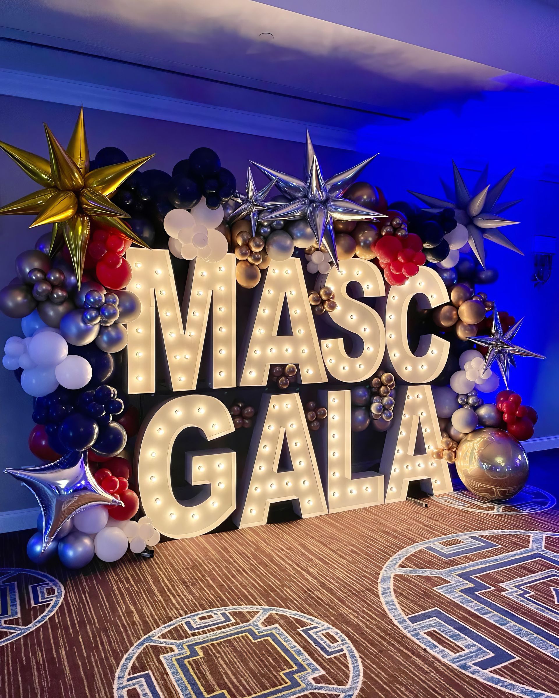 A dj is playing music at a party in a large room.