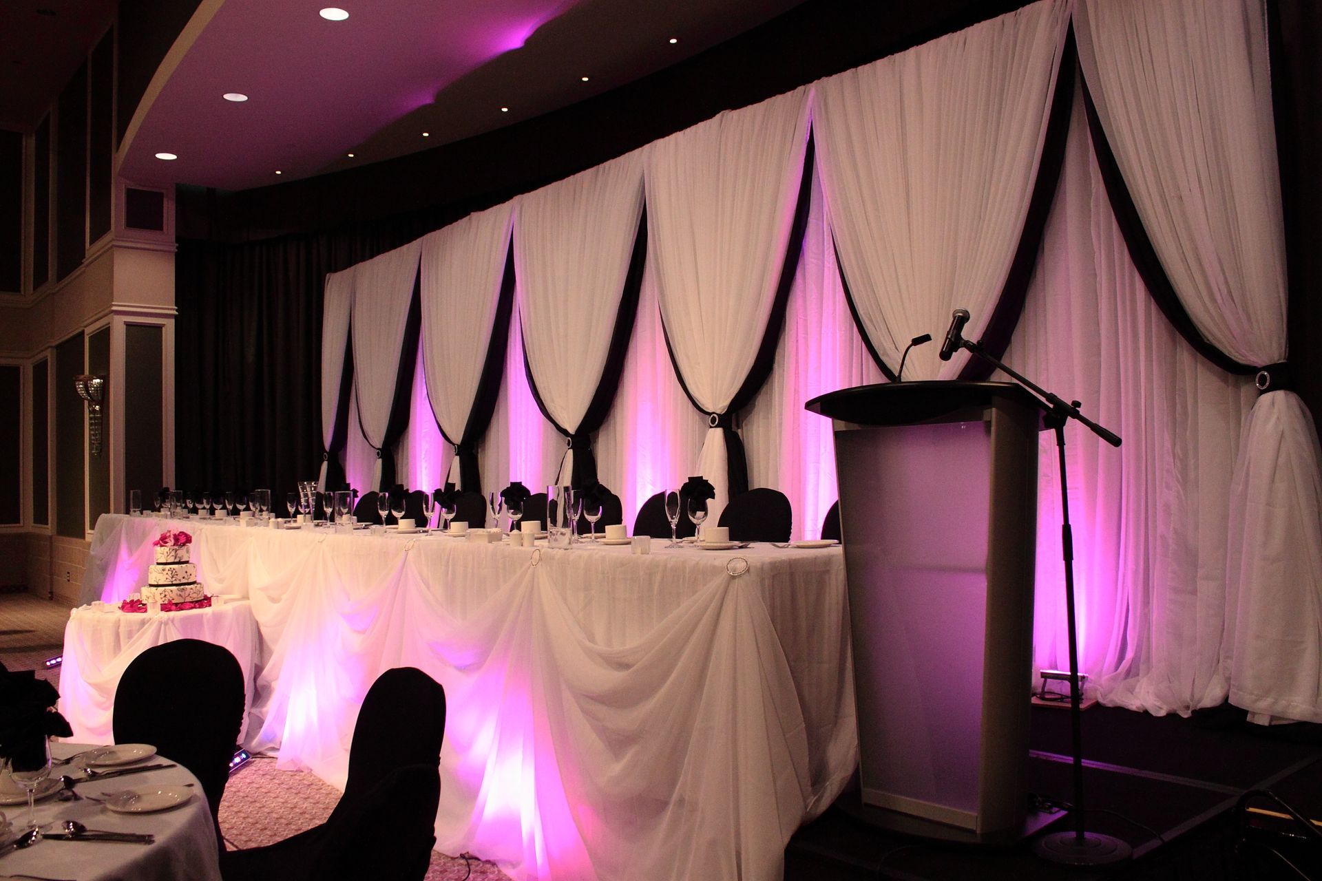 A long table with purple lights behind it and a podium