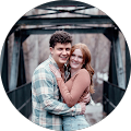 A man and a woman are hugging each other on a bridge.