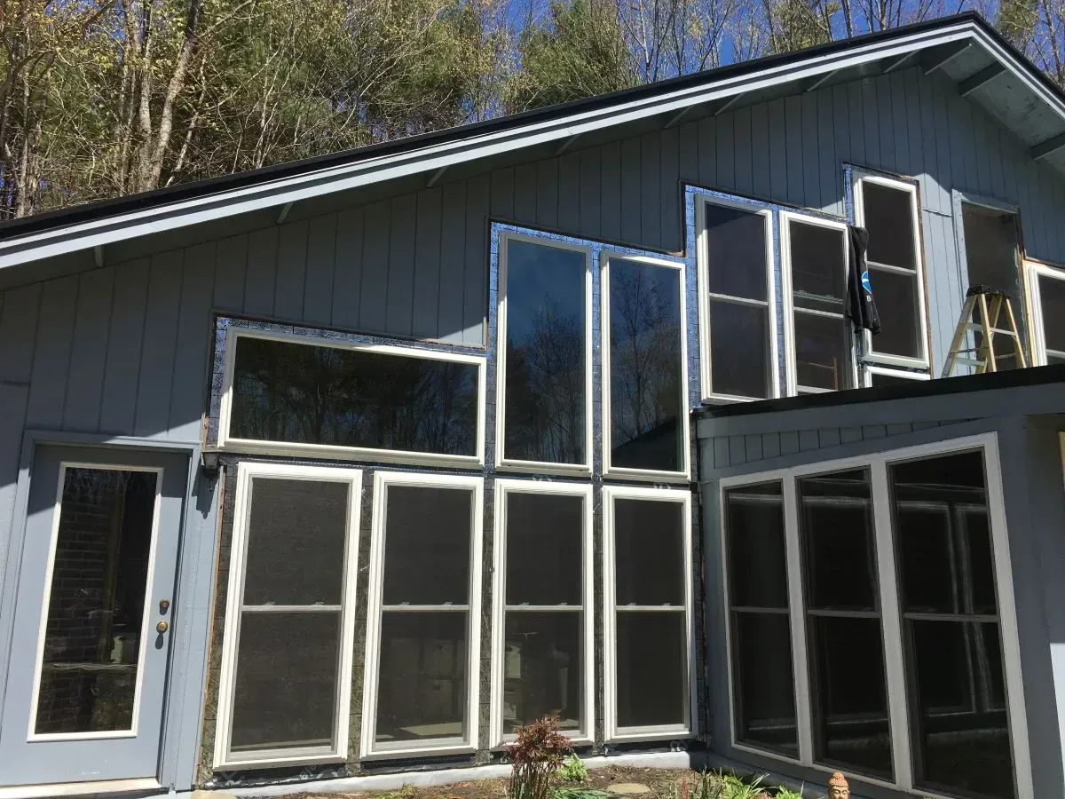 A modern house with a wooden door and a stone wall.