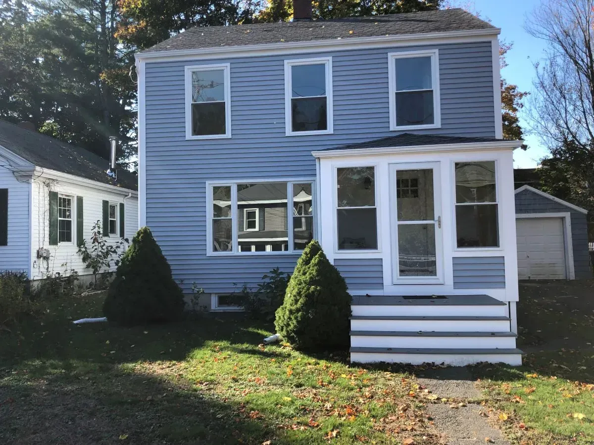 A blue house with a white porch and stairs