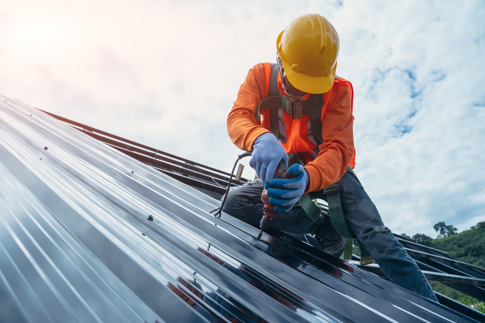 Roofing repair contractor, in special protective work wear and gloves, is fixing metal roofing.