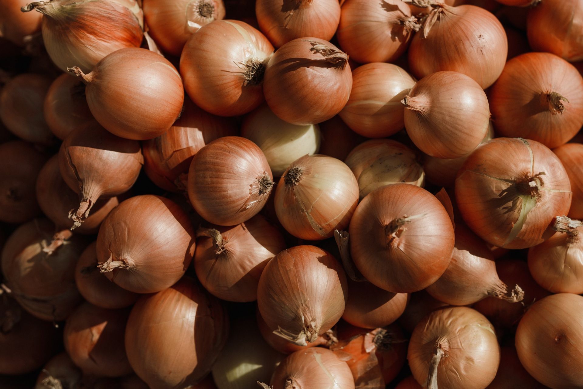A pile of onions sitting on top of each other on a table.
