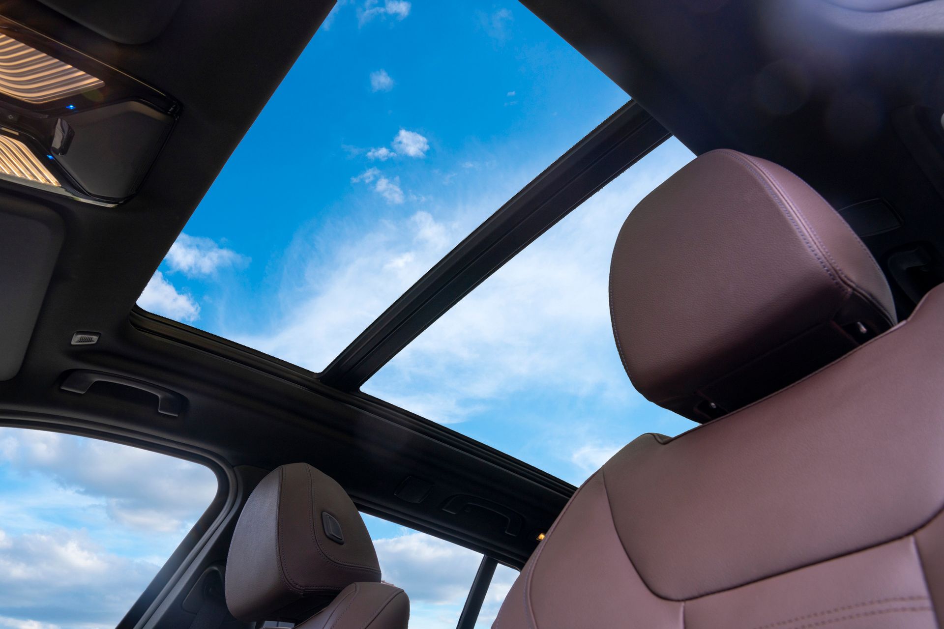 The sunroof of a car with a blue sky in the background