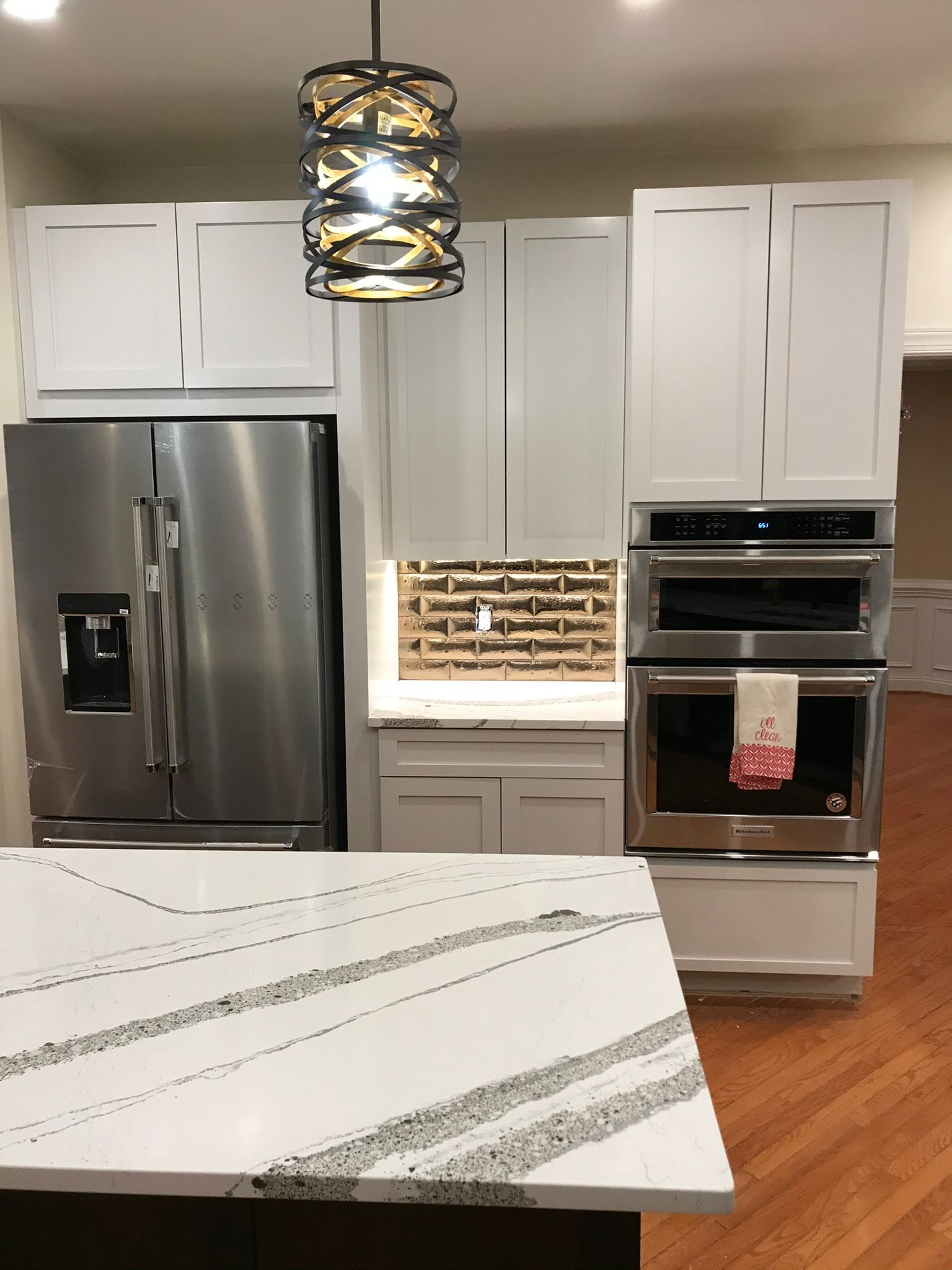 Kitchen with white cabinets, stainless steel appliances, and a marble-look countertop.