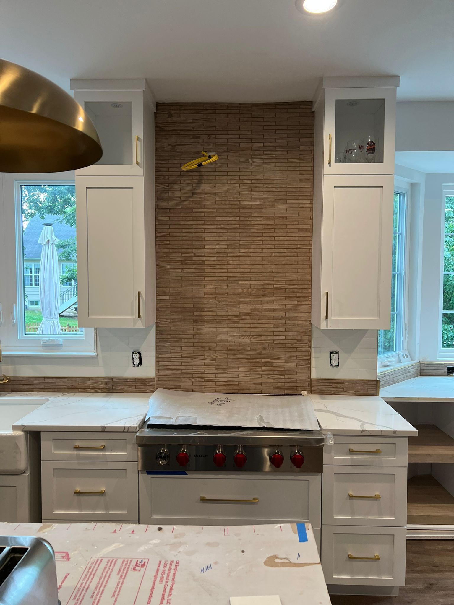 Kitchen with white cabinets, stone backsplash, and stainless steel range.