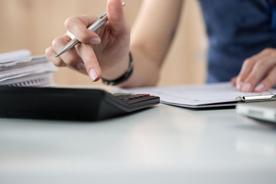 woman checking the data by using a calculator