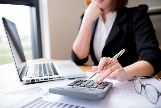 woman working on a laptop and doing calculations