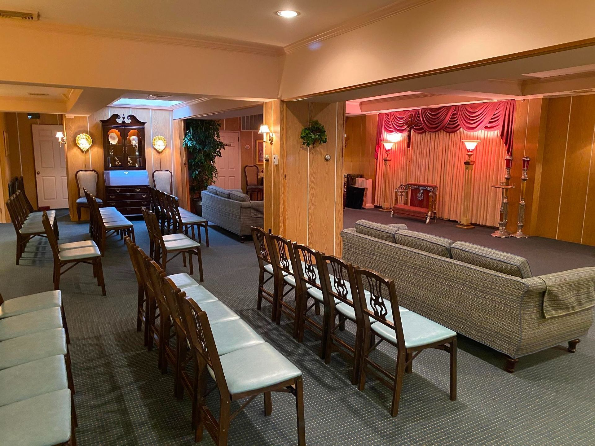 Funeral home interior with seating, stage, and neutral decor.