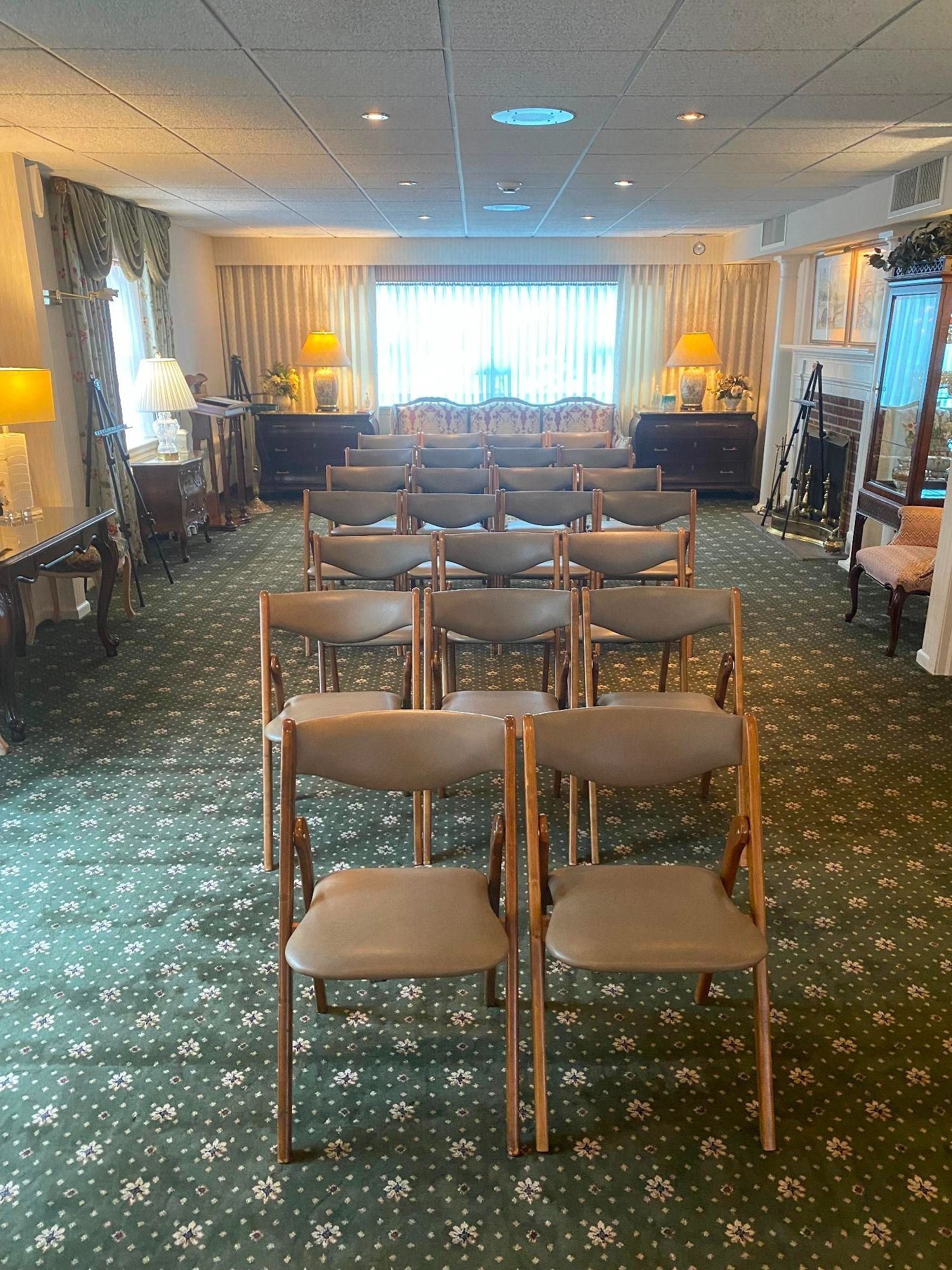 Rows of chairs face a window in a carpeted room; possibly a reception or ceremony space.