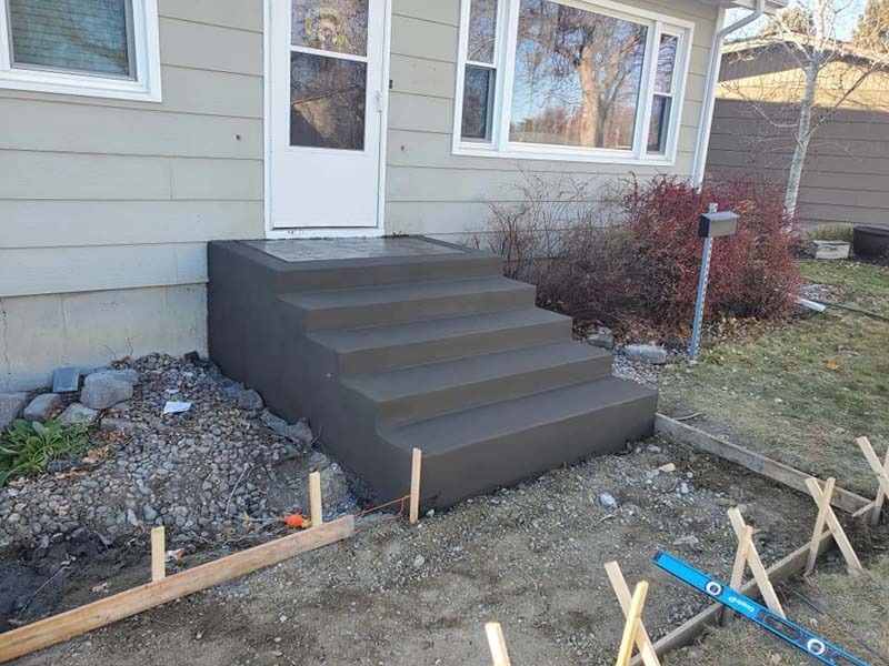 A concrete staircase is being built in front of a house.