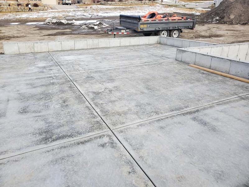 A truck is parked on a concrete surface in a construction site.