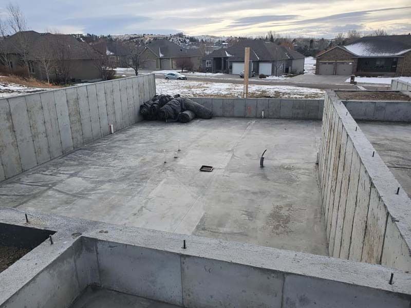 A large concrete foundation is being built in a residential area.