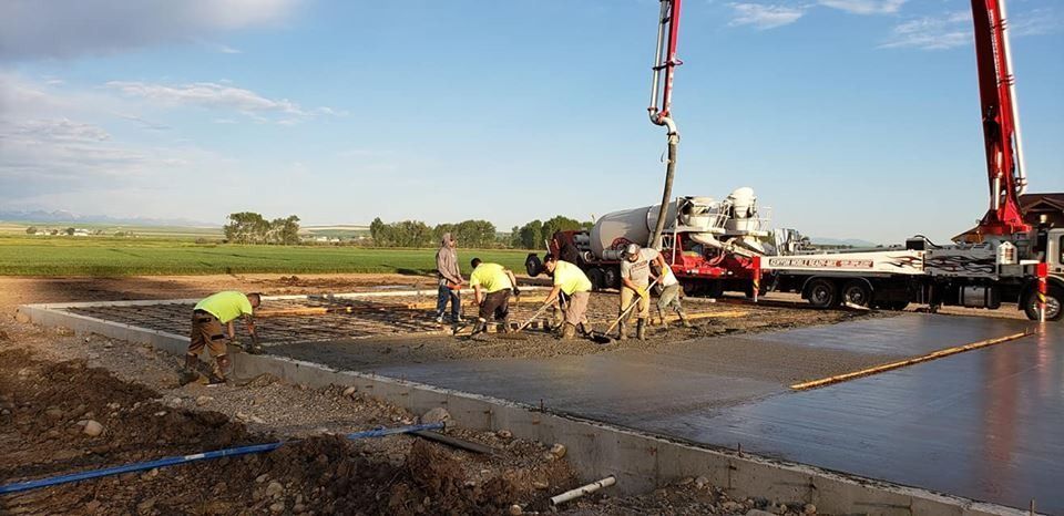 A group of construction workers are working on a concrete driveway.