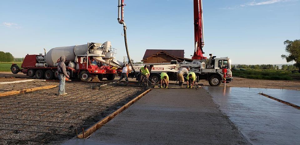 A group of construction workers are working on a concrete driveway.