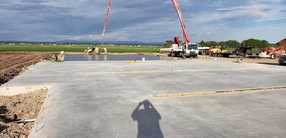 A shadow of a person is cast on a concrete surface.