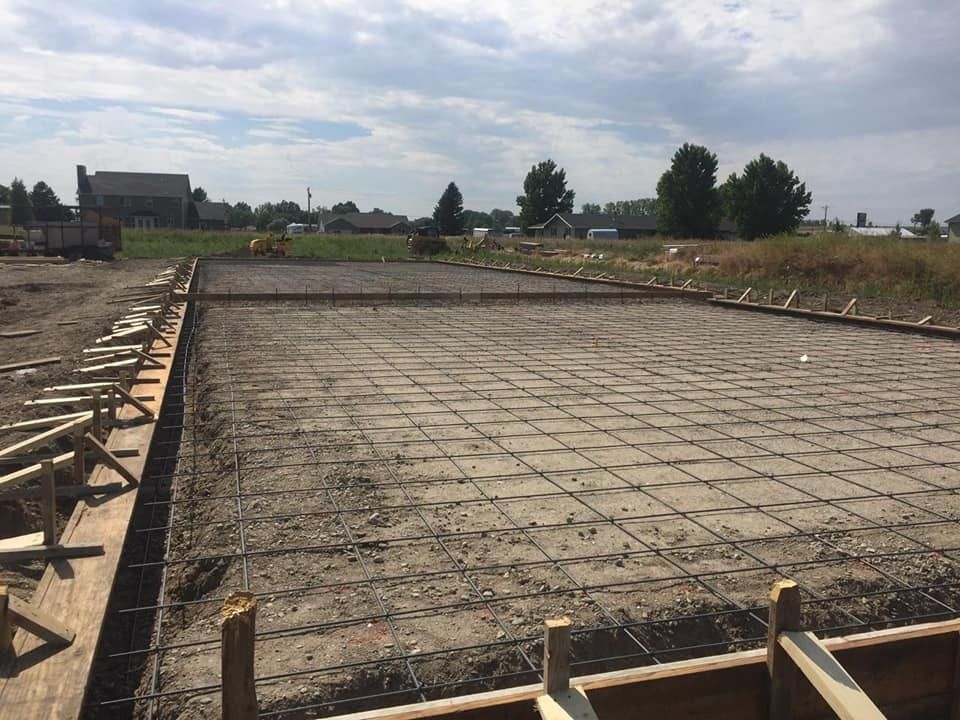 A large concrete slab is being built in a field.