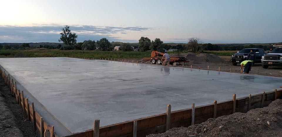 A large concrete slab is being built in a field.