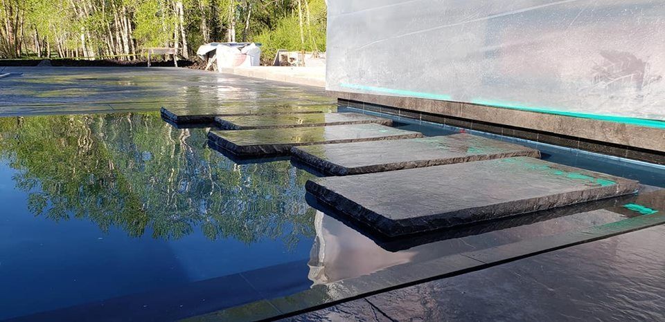A row of steps leading to a pool of water.