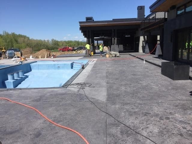 A large swimming pool is being built in front of a house.