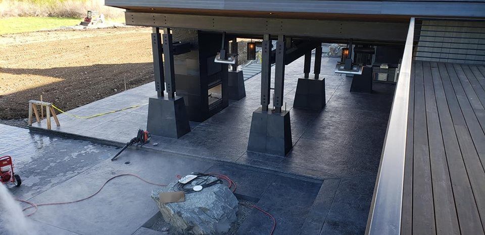 A large rock is sitting on the ground under a deck.