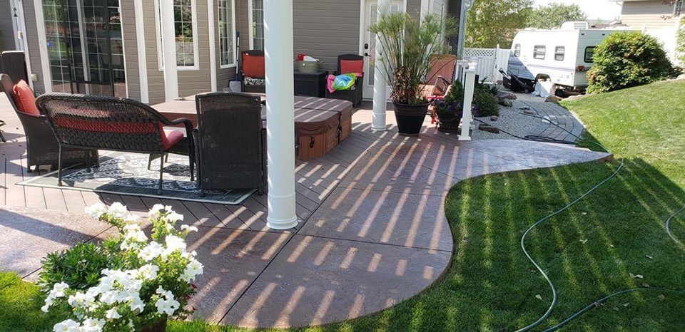 A patio with a couch , chairs and a table under a covered porch.
