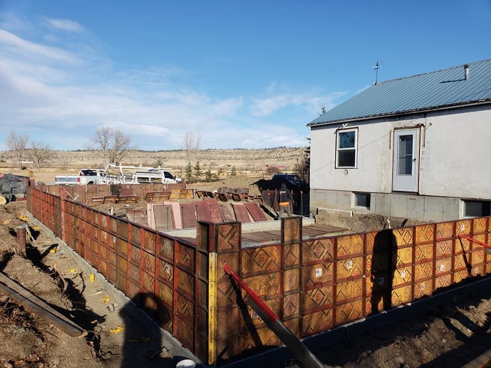 A house is being built in the middle of a dirt field.