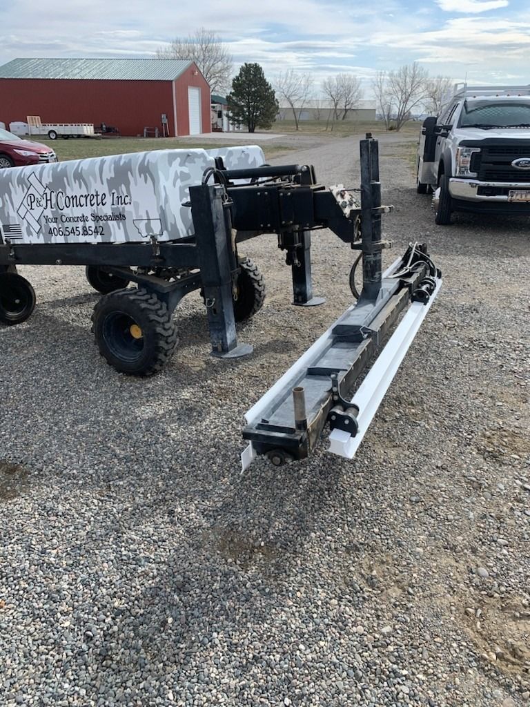 A truck is parked next to a trailer in a gravel lot.