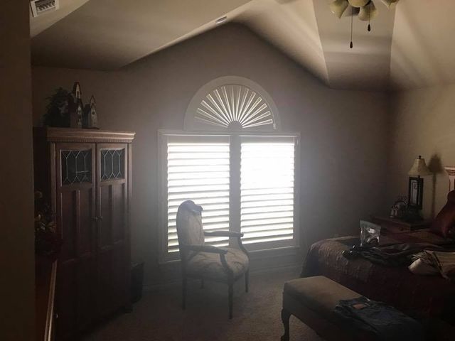 A Bedroom With Two Beds, A Chair, And A Window With Shutters – Lubbock, TX – Wilson Blind & Shutter