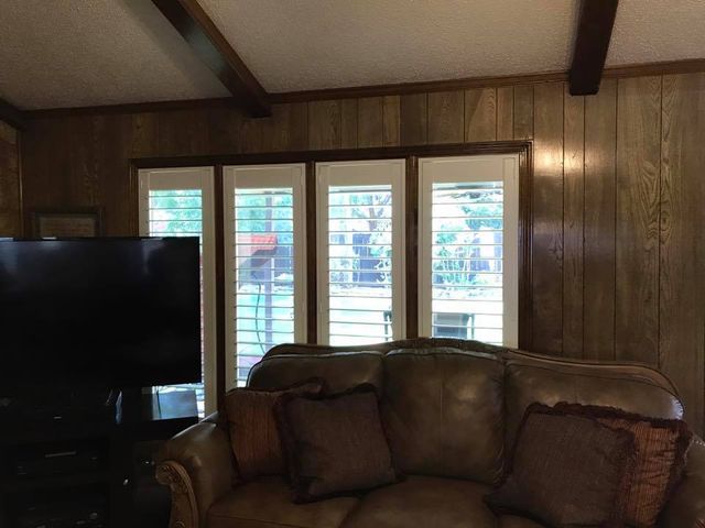 A Living Room With A Couch, Television, And Shutters On The Windows – Lubbock, TX – Wilson Blind & Shutter