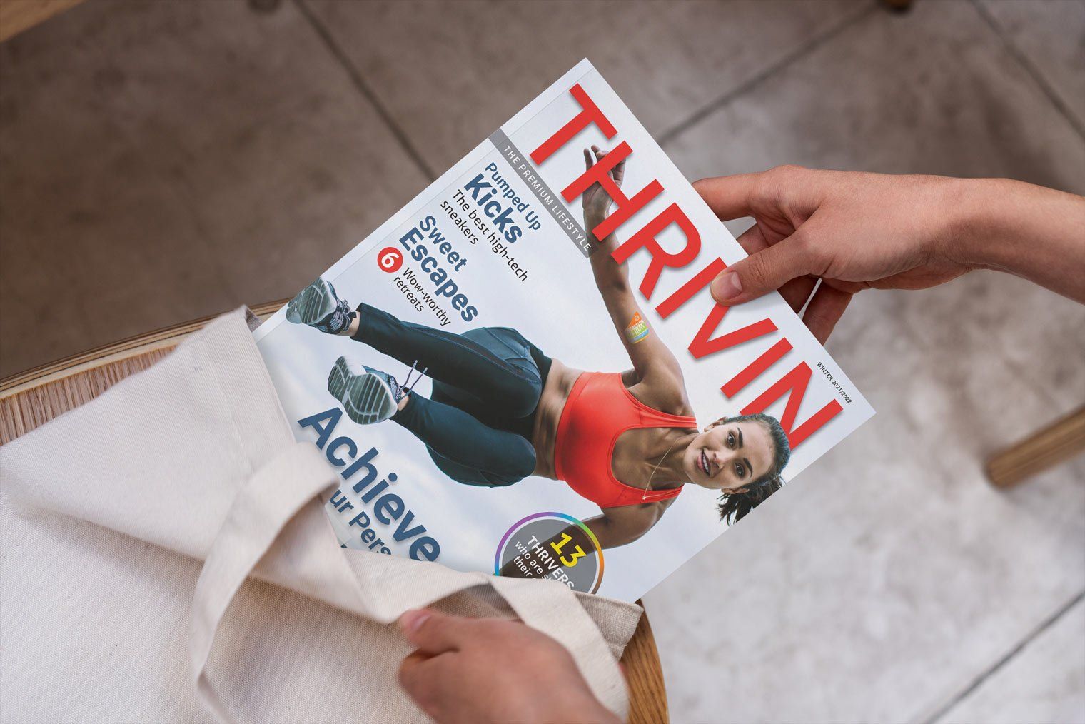 Hand pulling Thriving magazine out of tote bag